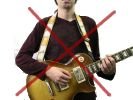 Incorrect guitar playing position with the strap over the head